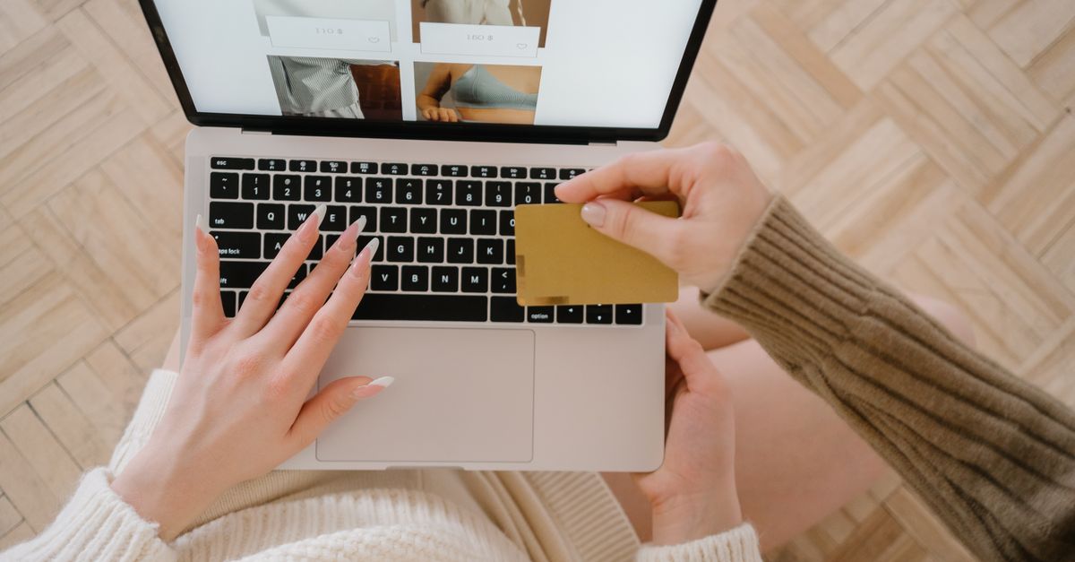 Person shopping online using a laptop and credit card, highlighting e-commerce convenience.